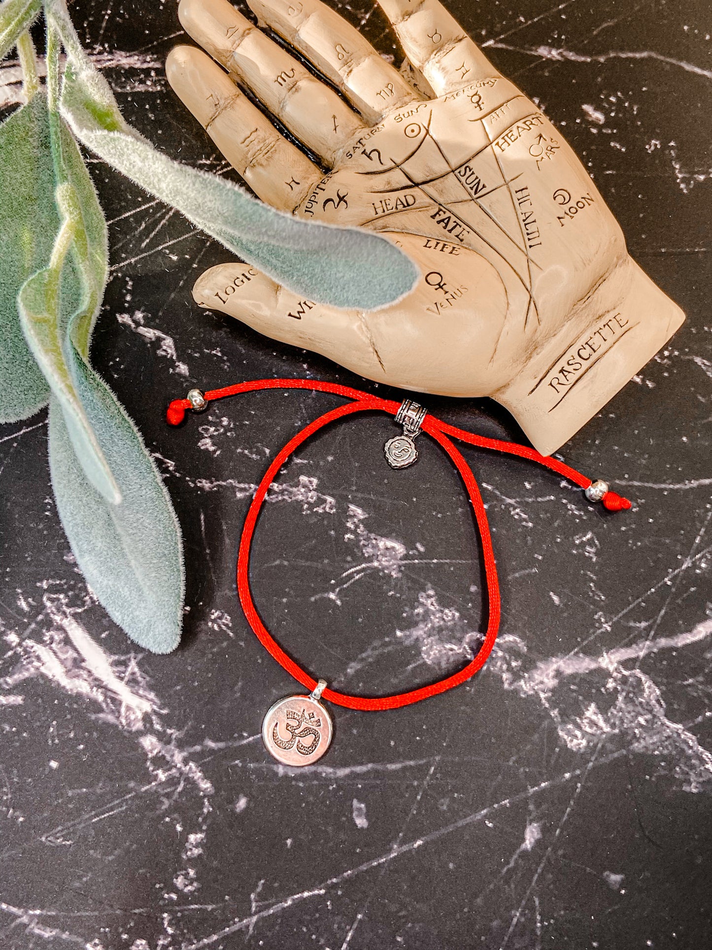 OM red string bracelet.